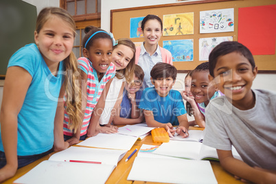 Teacher and pupils working at desk together