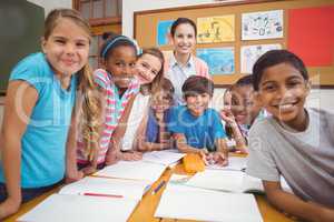 Teacher and pupils working at desk together