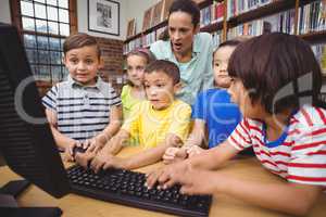 Pupils and teacher in the library using computer