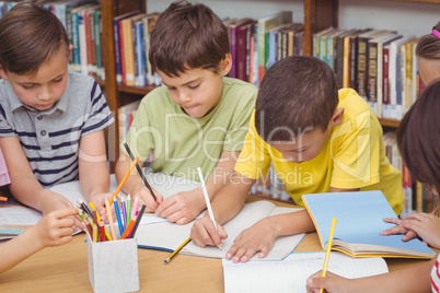 Pupils working together at desk in library