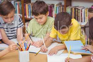 Pupils working together at desk in library