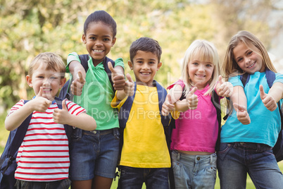 Smiling classmates doing thumbs up to camera