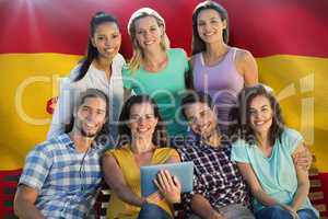 Composite image of smiling friends in the park using tablet pc