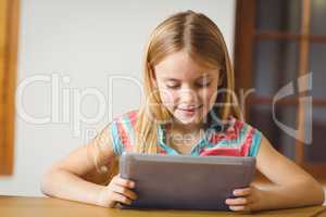 Cute pupil in class using tablet pc