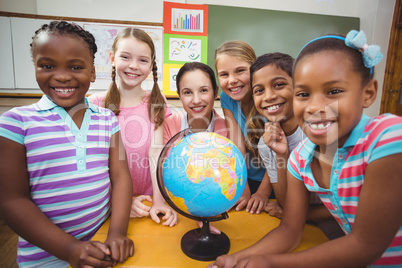 Teacher and pupils looking at globe