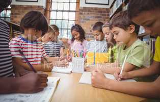 Pupils working together at desk in library