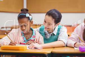 Teacher helping pupils during class