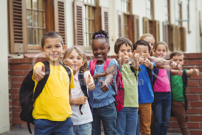 Cute pupils with schoolbags outside