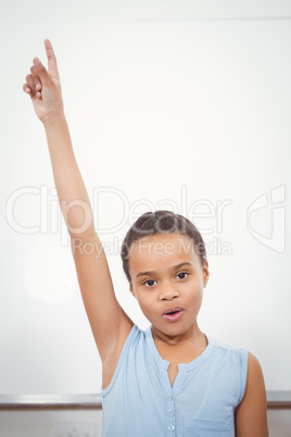 Pupil standing by whiteboard with raised arm