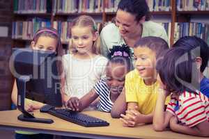 Pupils and teacher in the library using computer