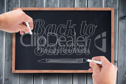 Composite image of business man writing with chalk