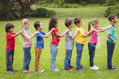 Cute pupils standing on the grass outside