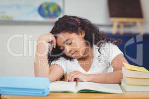 Concentrated pupil reading notepad in a classroom