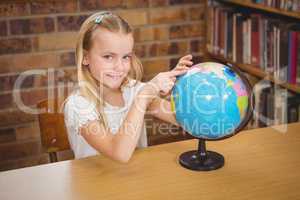 Students pointing to places on a globe