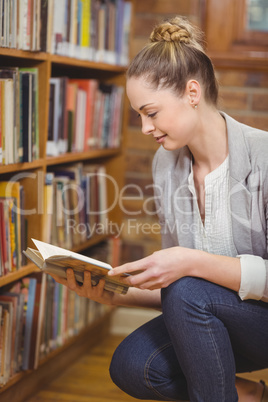 Blonde teacher searching book in the library