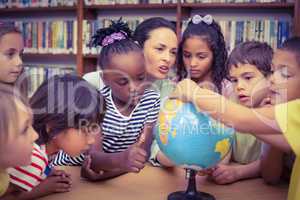 Pupils and teacher looking at globe in library