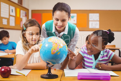 Teacher and pupils looking at globe