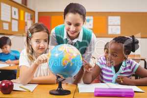 Teacher and pupils looking at globe