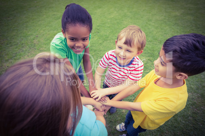 Smiling classmates putting hands together