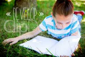 Develop against cute little girl reading in park