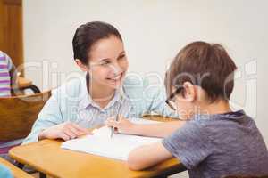 Teacher helping a little boy during class