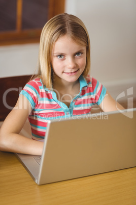 Cute pupil in class using laptop