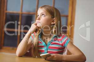 Cute pupil in class using smartphone