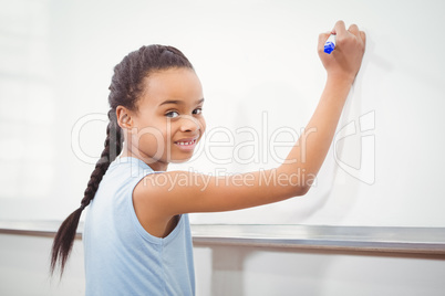 Smiling student writing on whiteboard