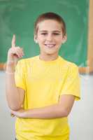 Smiling pupil raising hand in a classroom