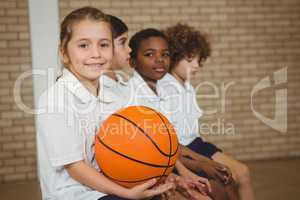 Student holding basketball with fellow players