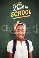 Composite image of little girl smiling in school corridor