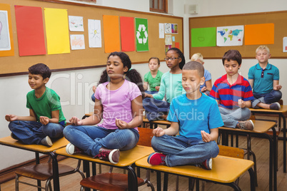 Pupils meditating on classroom desks