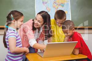 Students and teacher using a laptop