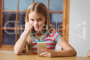 Cute pupil in class using smartphone