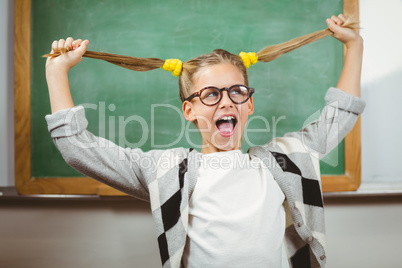 Cute pupil pulling her hair in a classroom