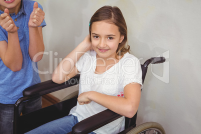 Disabled pupil smiling at camera with classmates