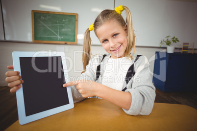 Smiling pupil pointing on tablet in a classroom