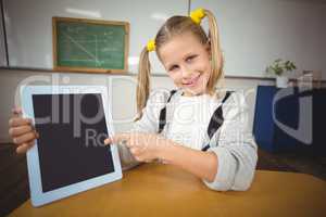 Smiling pupil pointing on tablet in a classroom