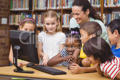 Pupils and teacher in the library using computer