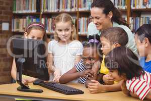 Pupils and teacher in the library using computer