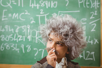 Little Einstein thinking in front of chalkboard