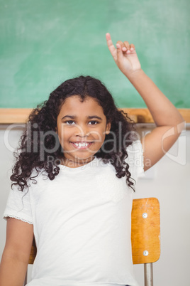 Cute pupil raising hand in a classroom