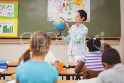 Pupils listening to their teacher holding globe