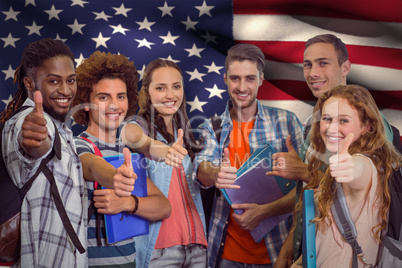 Composite image of smiling group of students doing thumbs up