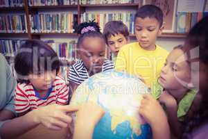 Pupils looking at globe in library