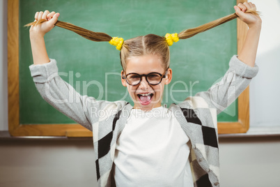 Cute pupil pulling her hair in a classroom