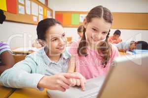 Teacher using laptop with pupil