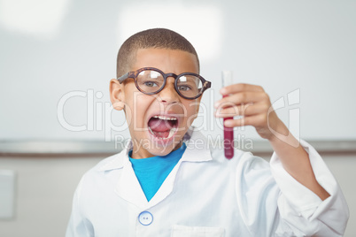 Surprised pupil with lab coat looking at test tube