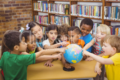 Students pointing at a globe