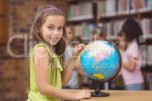 Pupil in library pointing to globe